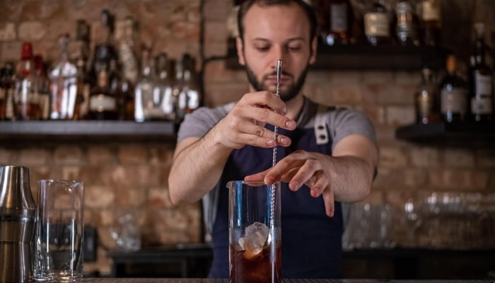 Andrei Marcu mixing a cocktail